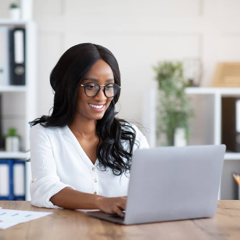 Photo of a woman typing on a laptop.